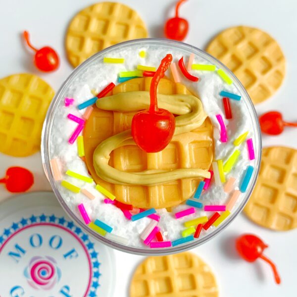 Waffle Sundae is a butterscotch scented butter slime. It is topped with white glitter and rainbow sprinkles. It then comes with a 1 oz butterscotch syrup slime, a waffle charm, and a cherry charm to decorate your slime!